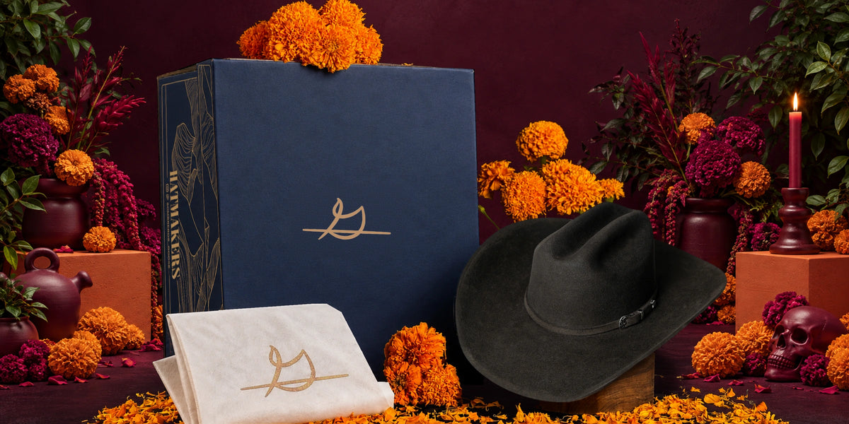 Sombrero John con caja azul y bolsa cubrepolvos Goose Western en un altar de Día de Muertos