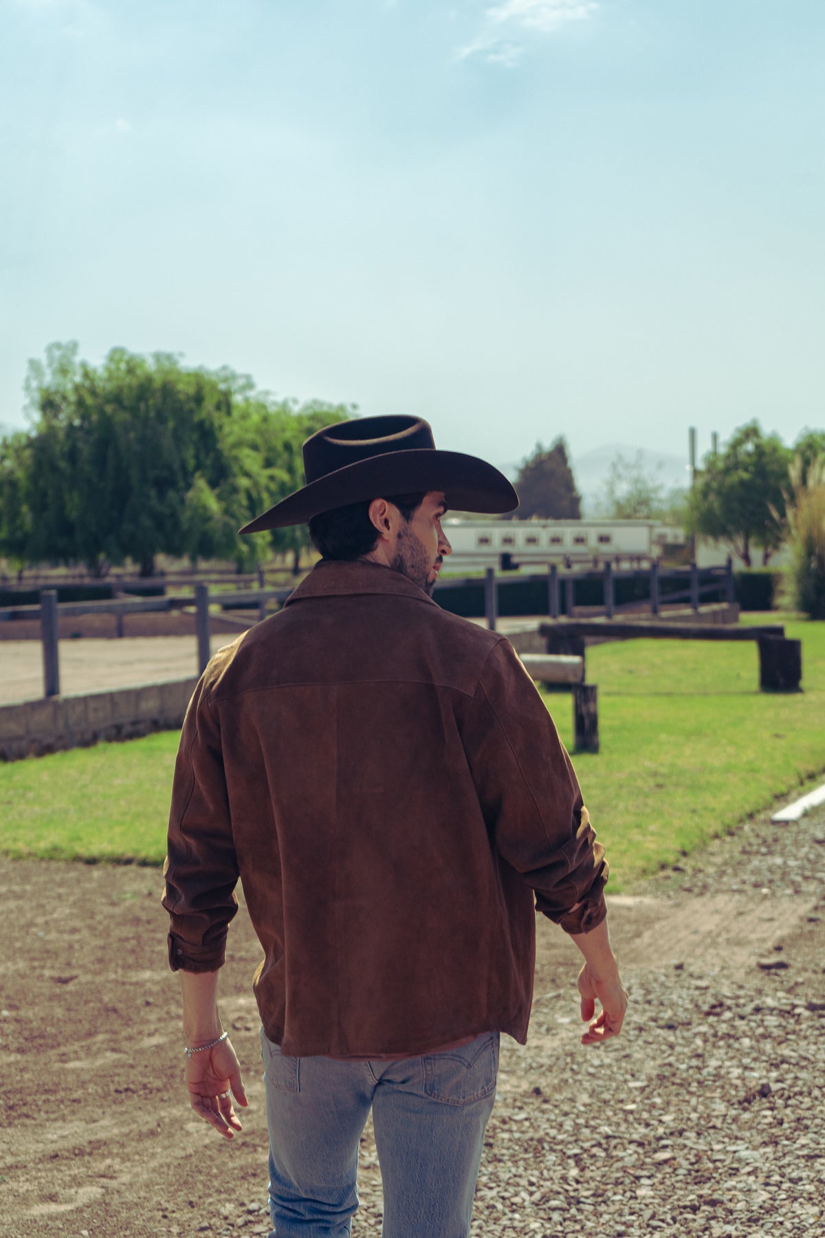 Sombrero John café oscuro en hombre, vista posterior en el rancho