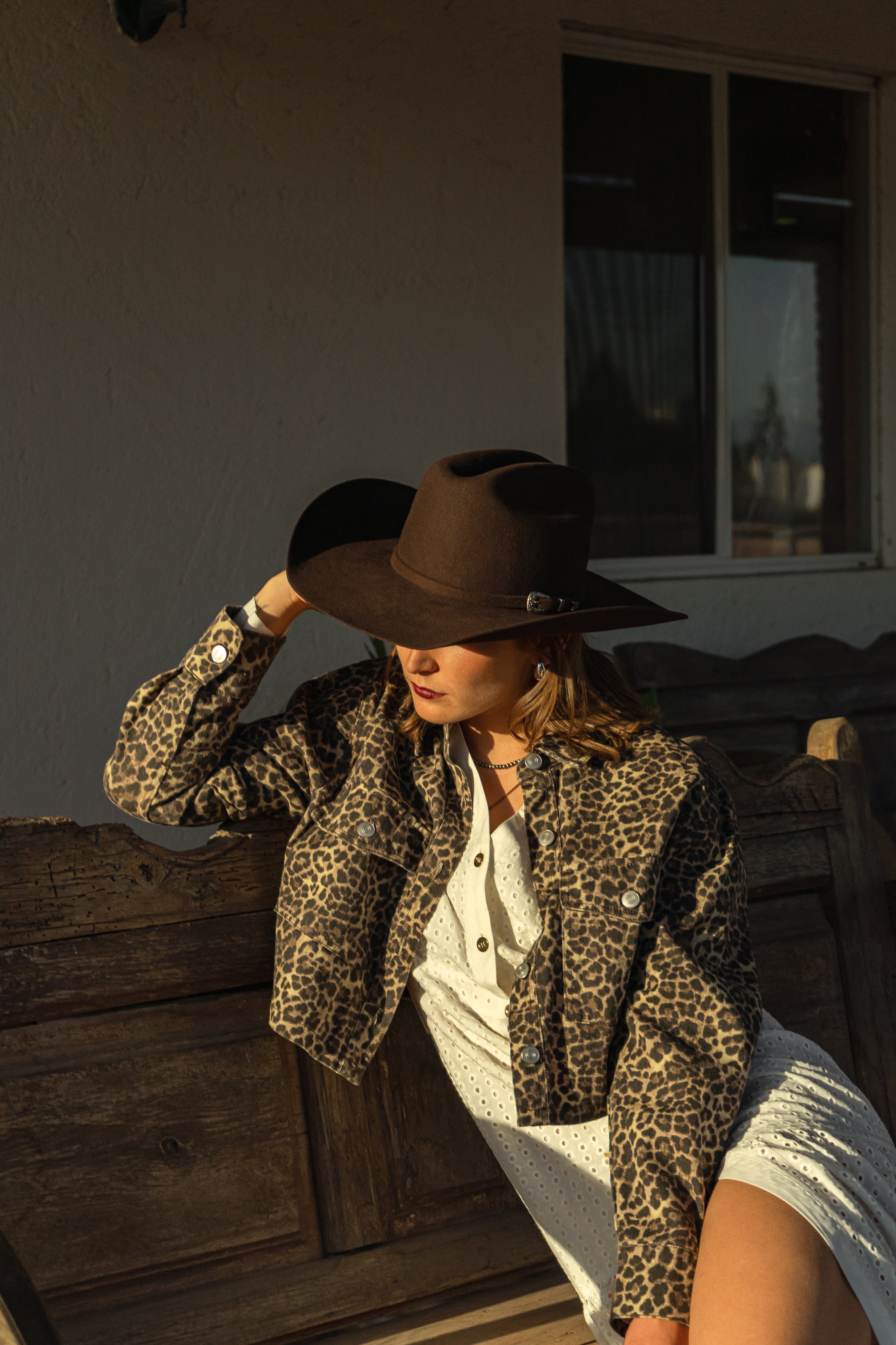 Sombrero John café oscuro en mujer con chaqueta estampada en el rancho
