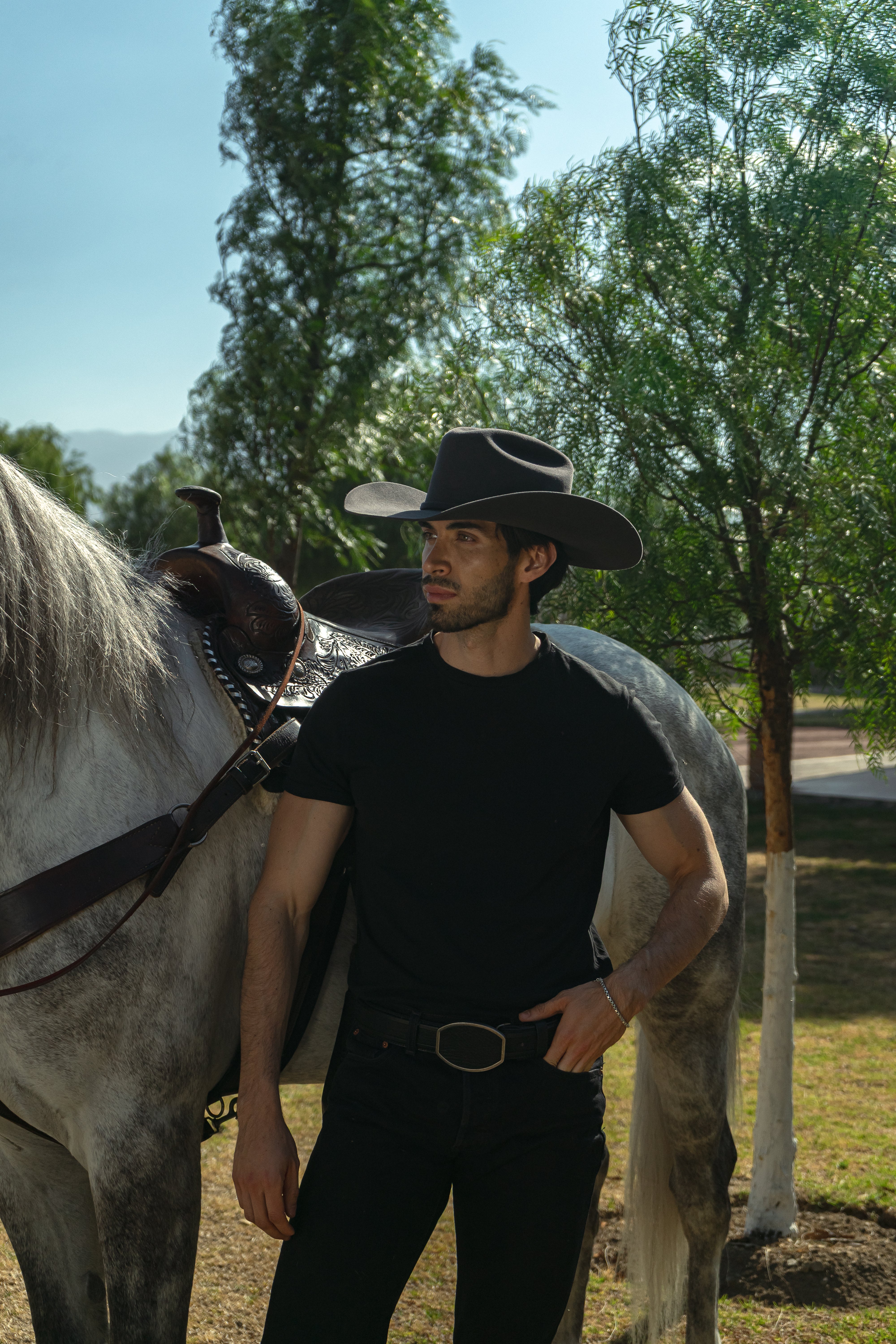 Sombrero John gris en modelo hombre junto al caballo