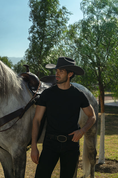 Sombrero John gris en modelo hombre junto al caballo