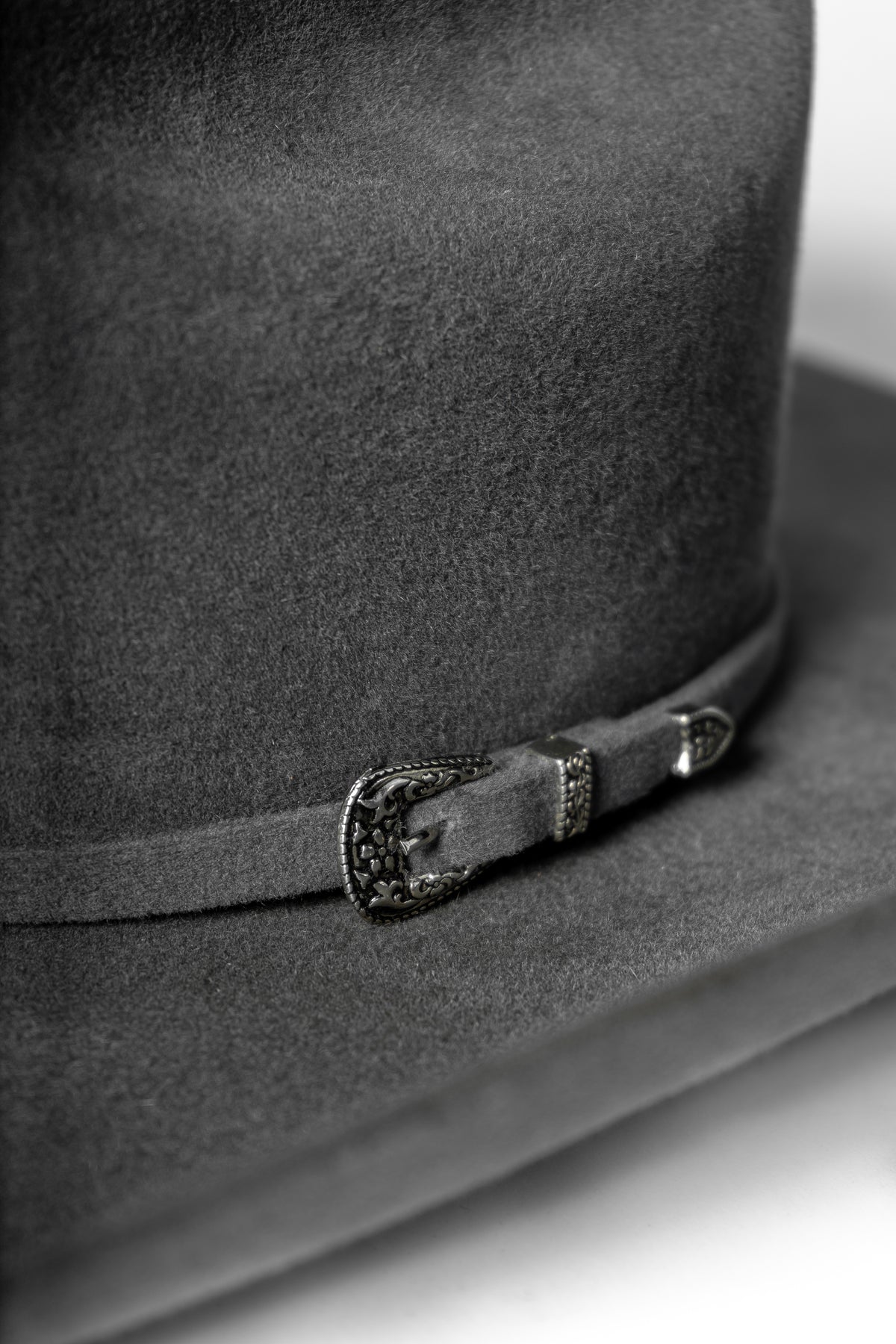 Detalle del herraje de tres piezas y textura del sombrero John gris